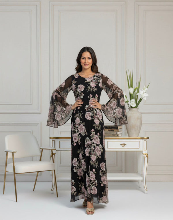Woman in a floral dress standing in a stylish room with decor elements.